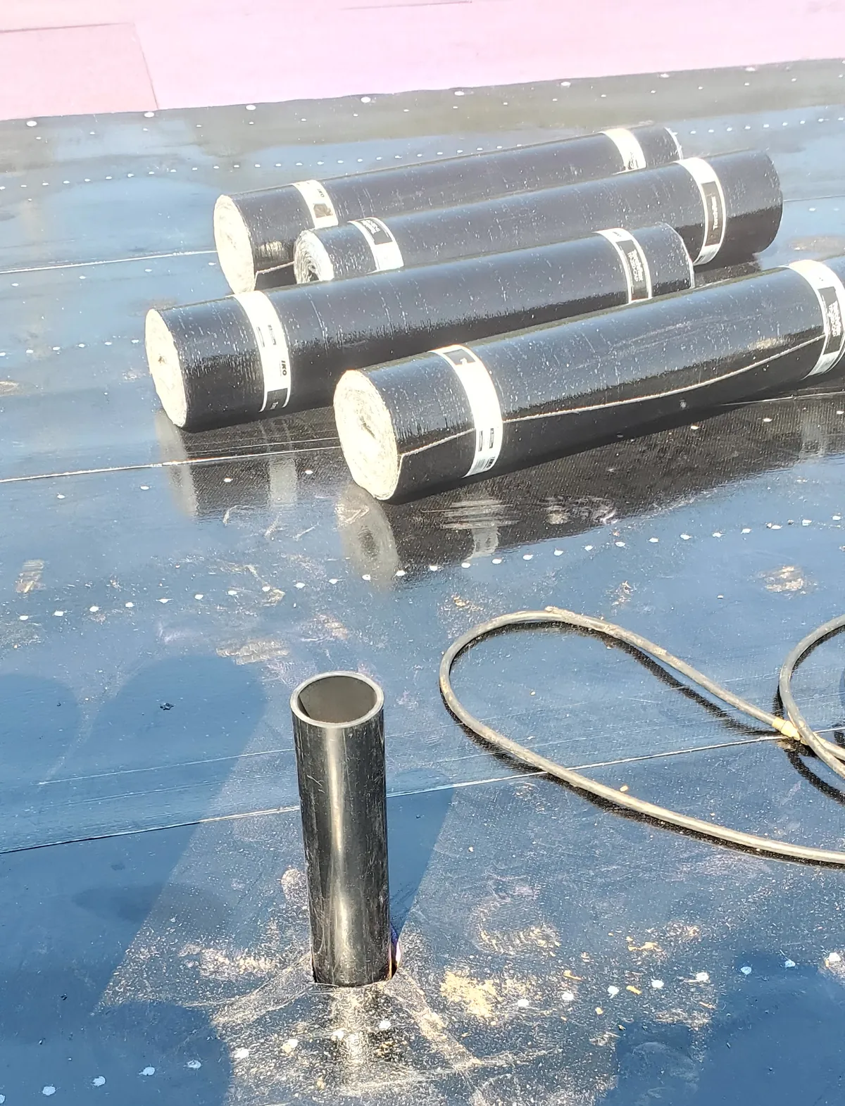 Rouleaux de membrane élastomère de finition sur la sous-couche, en cours de pose